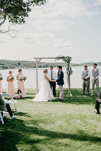 A couple at ceremony by the lake