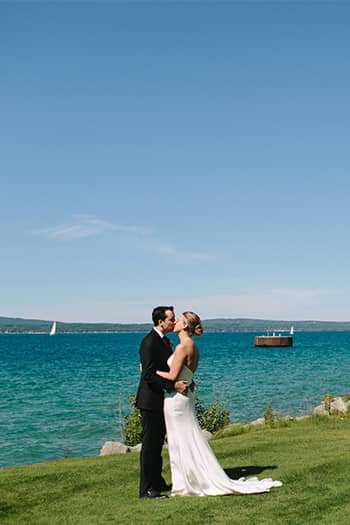 Bride and groom kissing in front of the bay